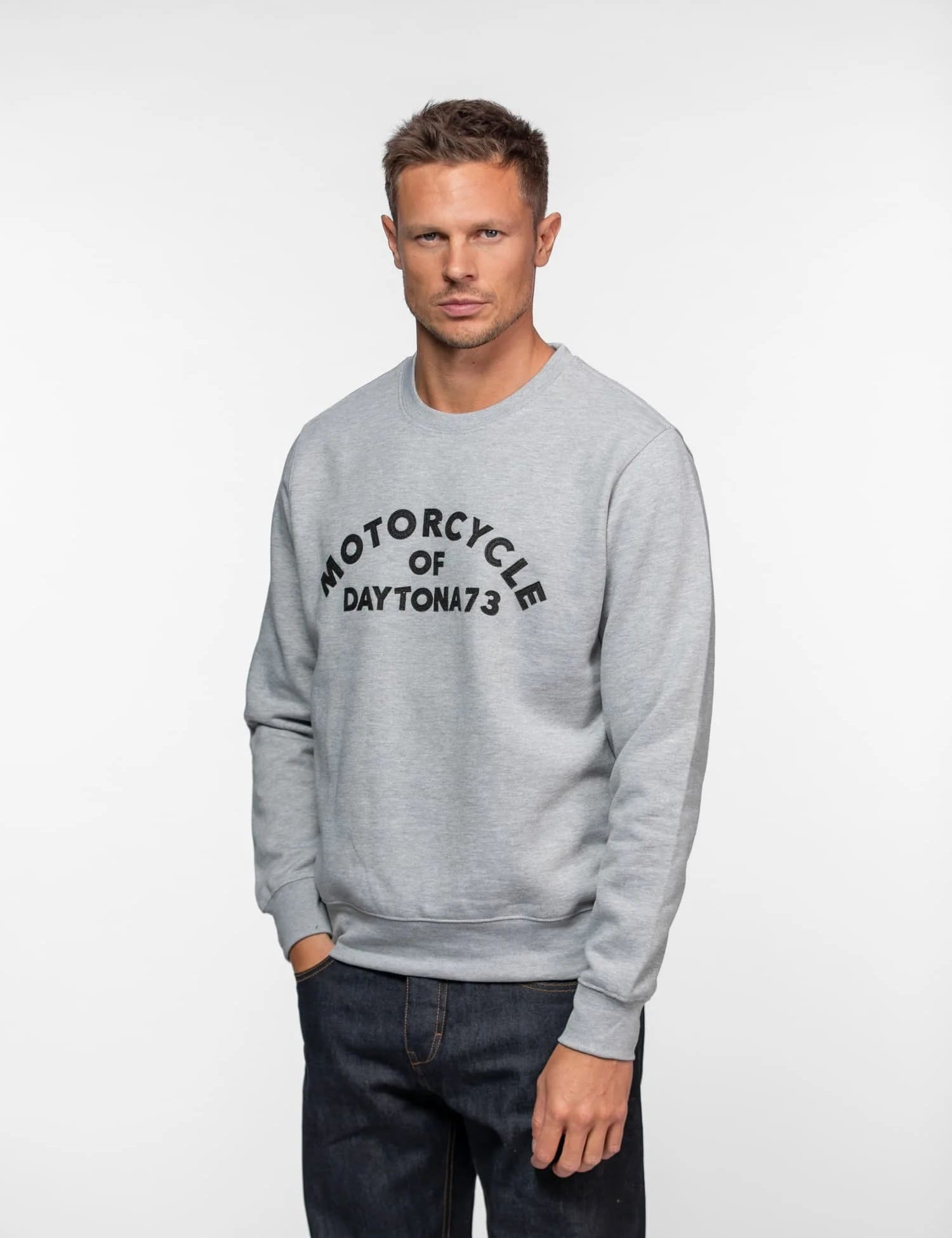 Homme en sweat gris avec logo sur fond blanc.