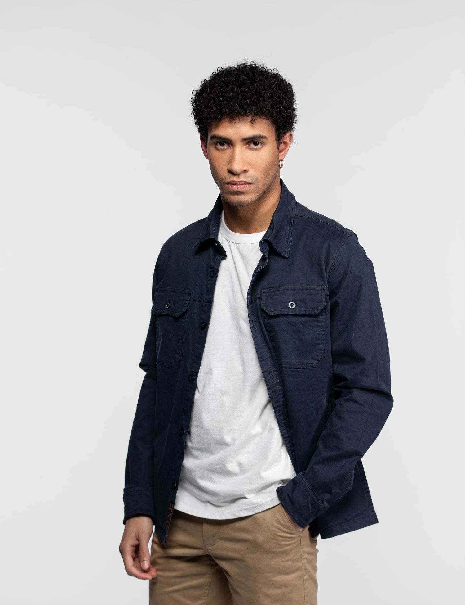 Pull bleu marine à manches longues avec un écusson sur l'épaule.