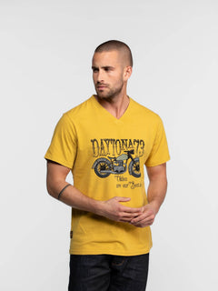 Homme portant un t-shirt jaune avec illustration de moto.