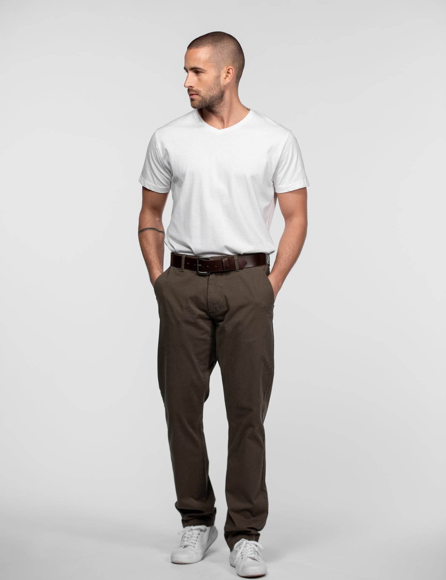T-shirt blanc à col en V et pantalon marron olive.