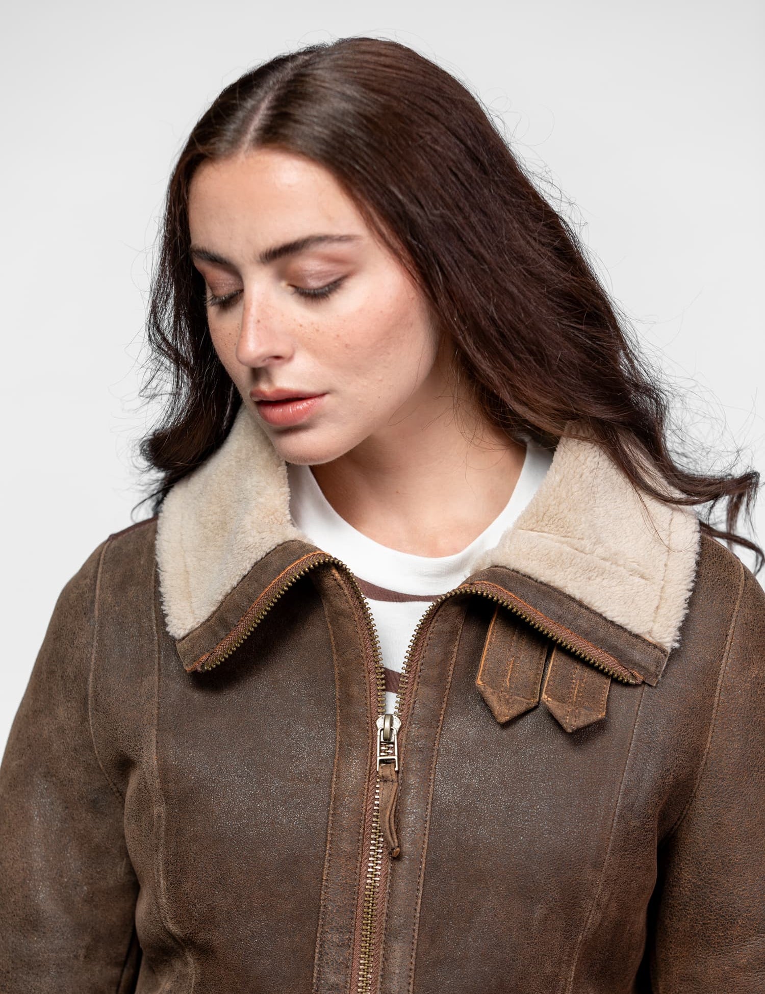 Veste en peau lainée marron avec col blanc et fermeture éclair.