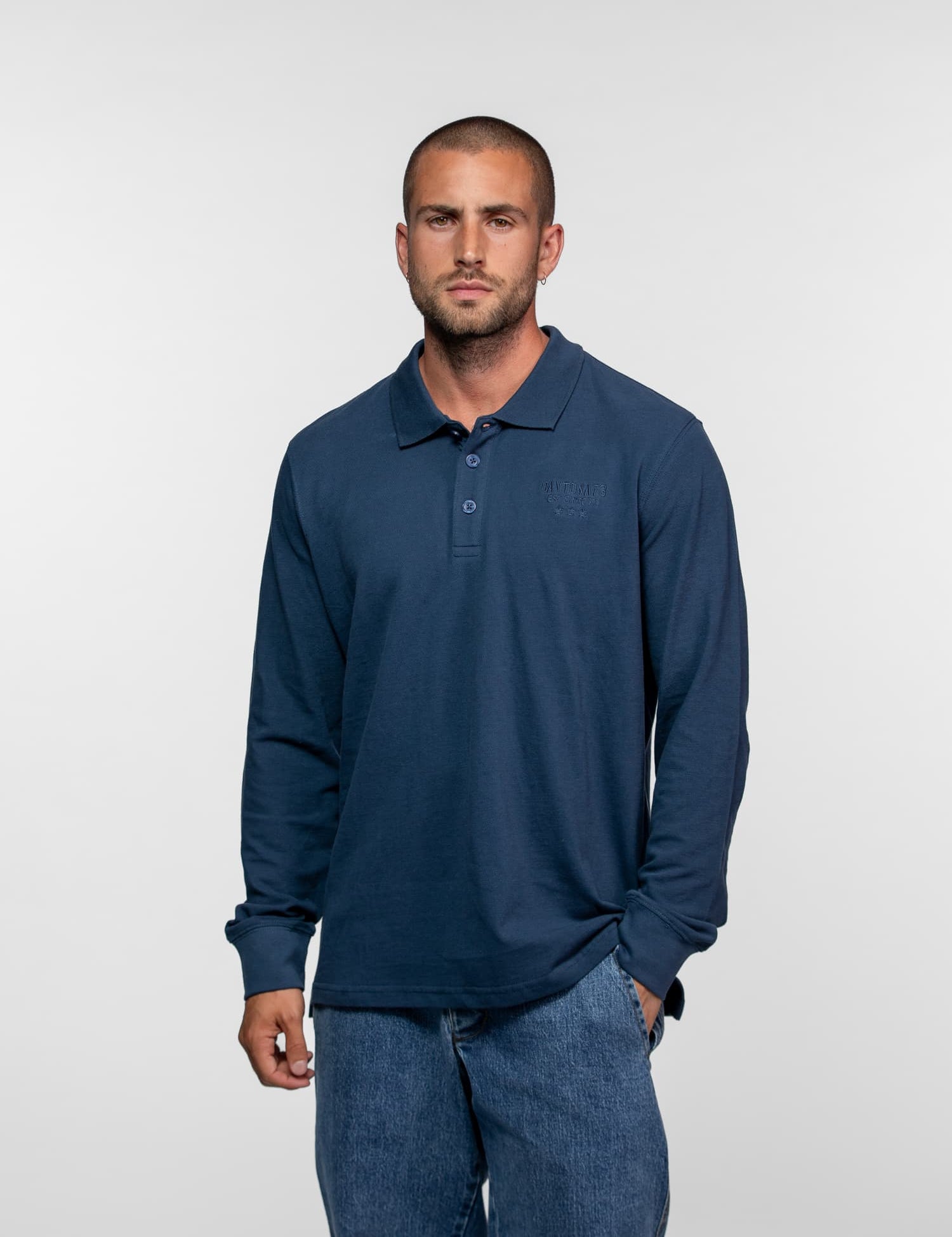 Homme portant un polo bleu à manches longues.