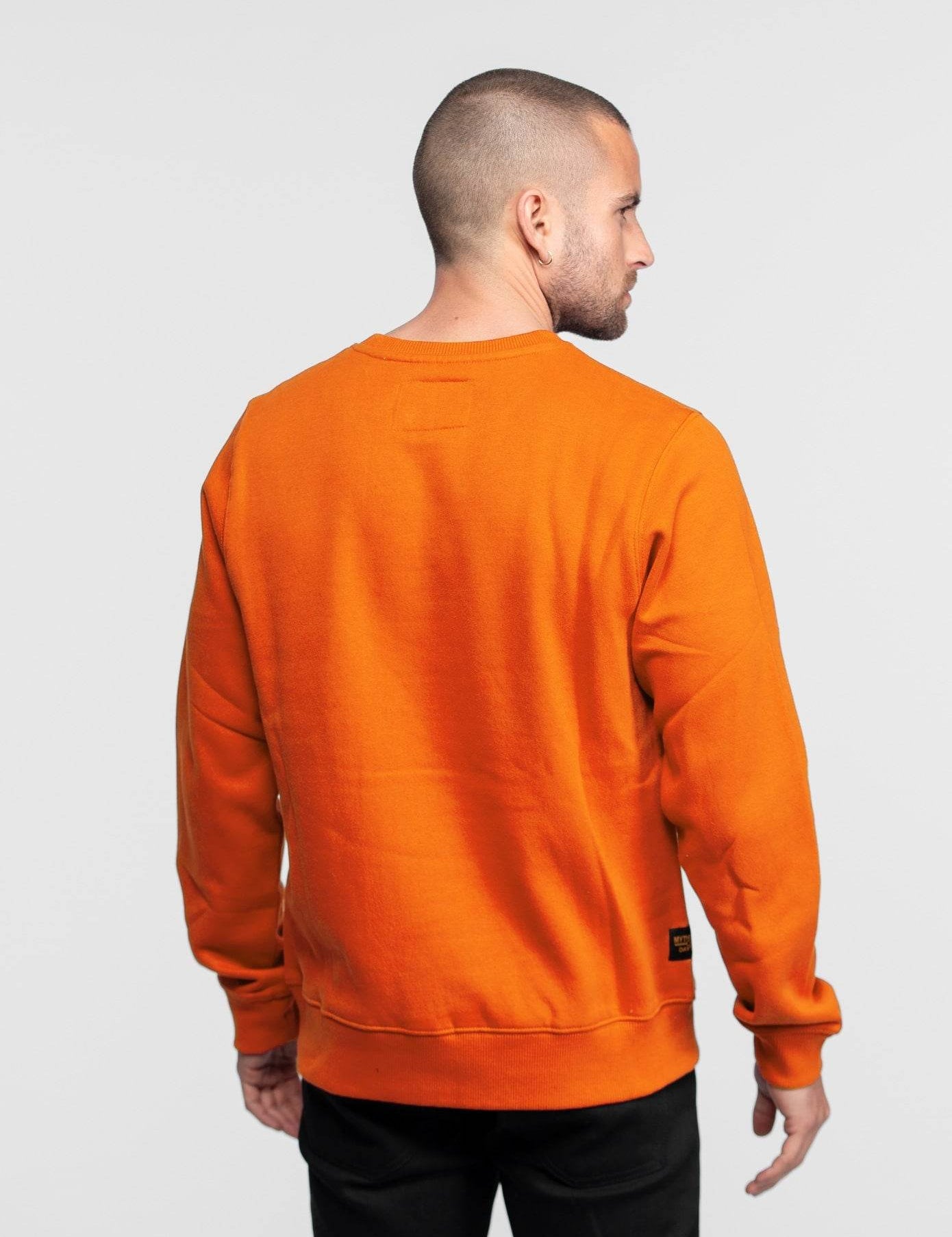 Homme de dos portant un sweat orange.