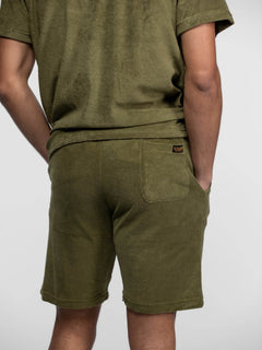 Homme de dos portant un ensemble short éponge vert.