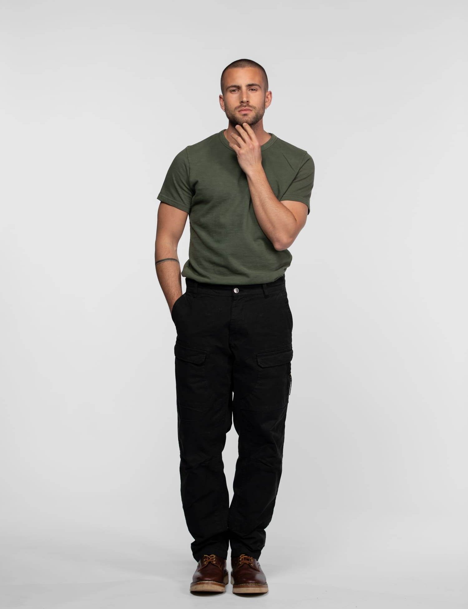 Homme en t-shirt vert et pantalon cargo noir.