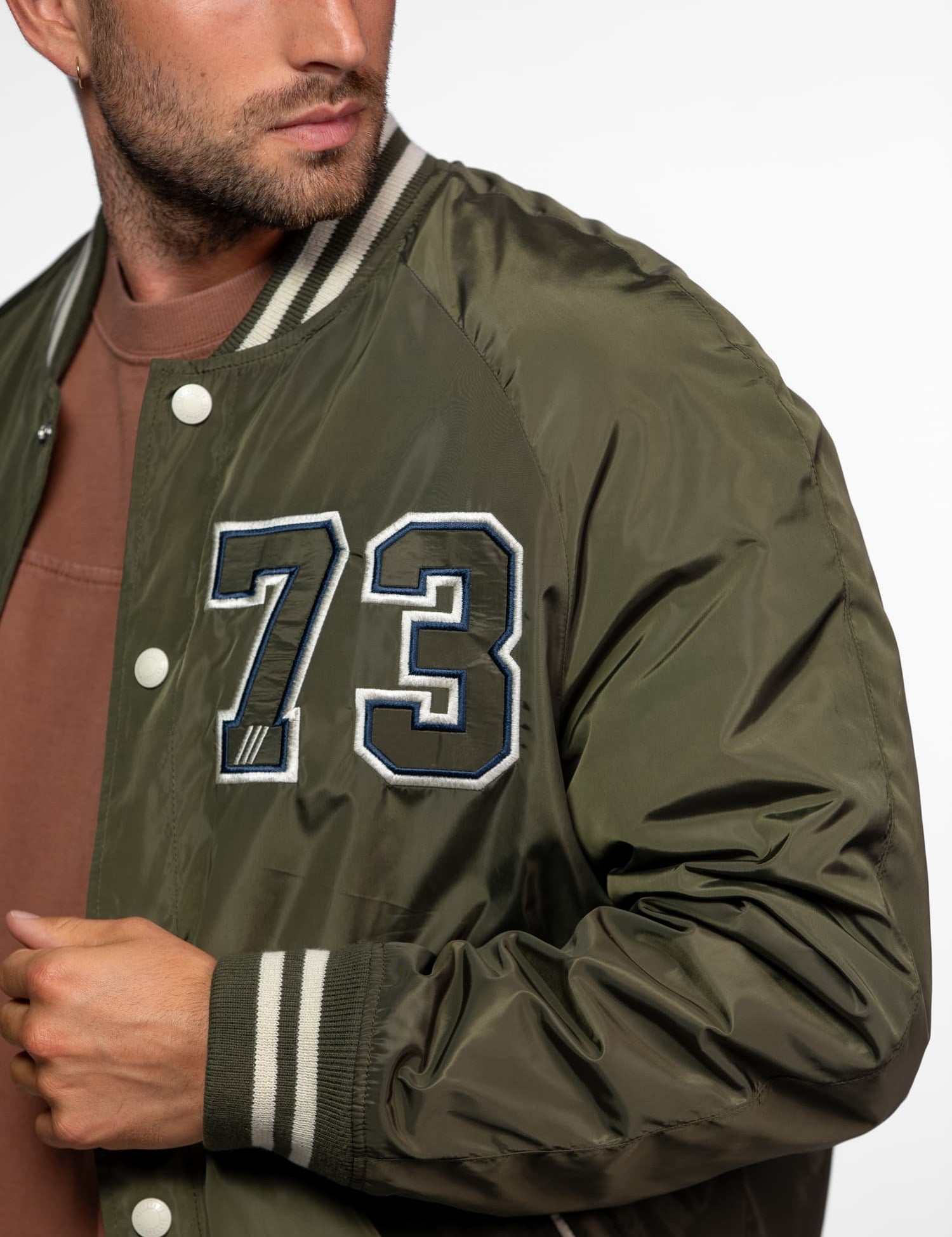 Veste teddy vert olive avec patch brodé du chiffre 73.