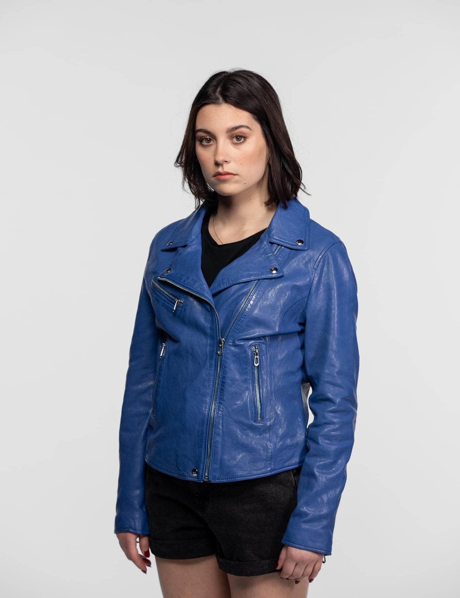 Femme portant un blouson en cuir bleu et short.