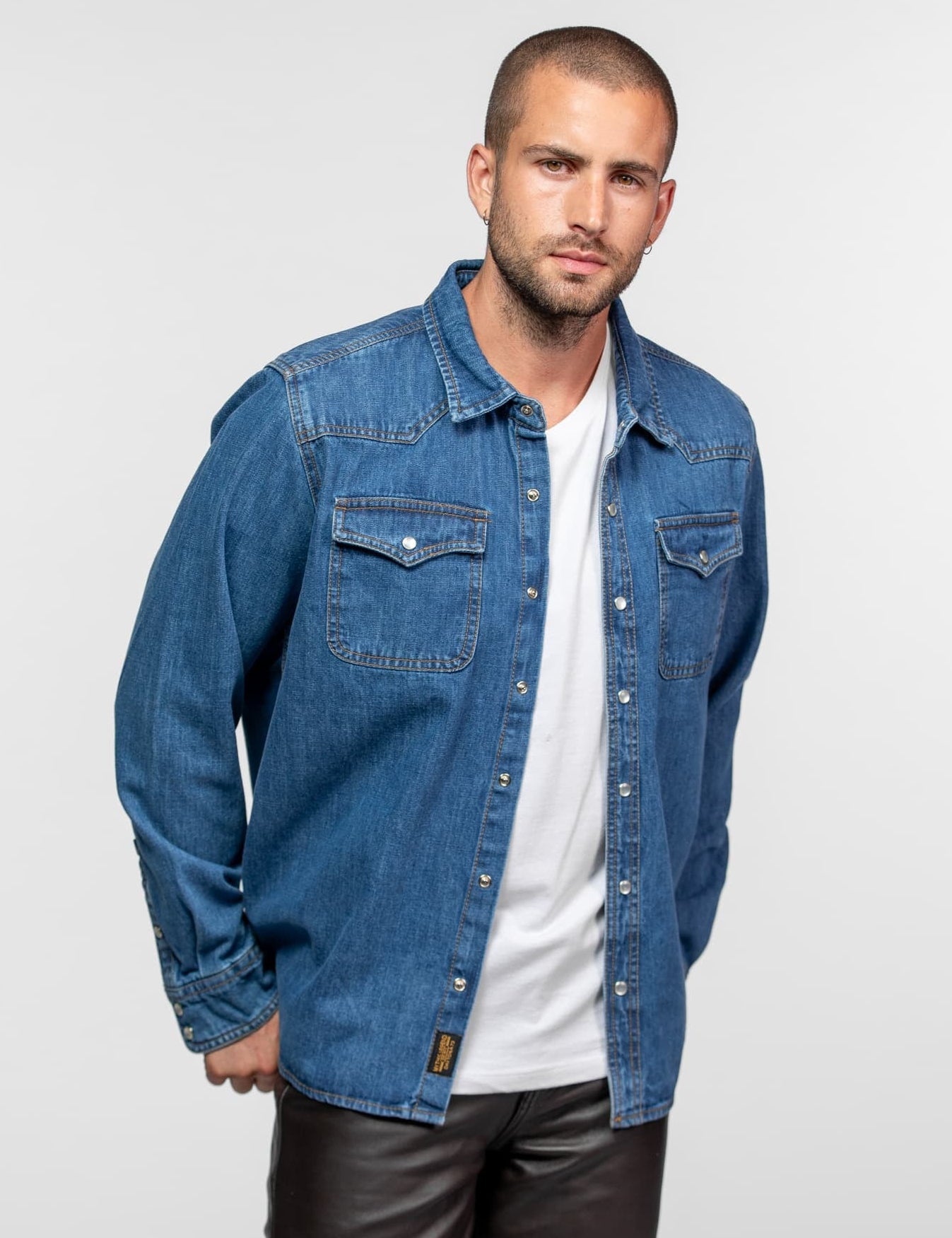 Chemise en jean bleu sur t-shirt blanc et pantalon.