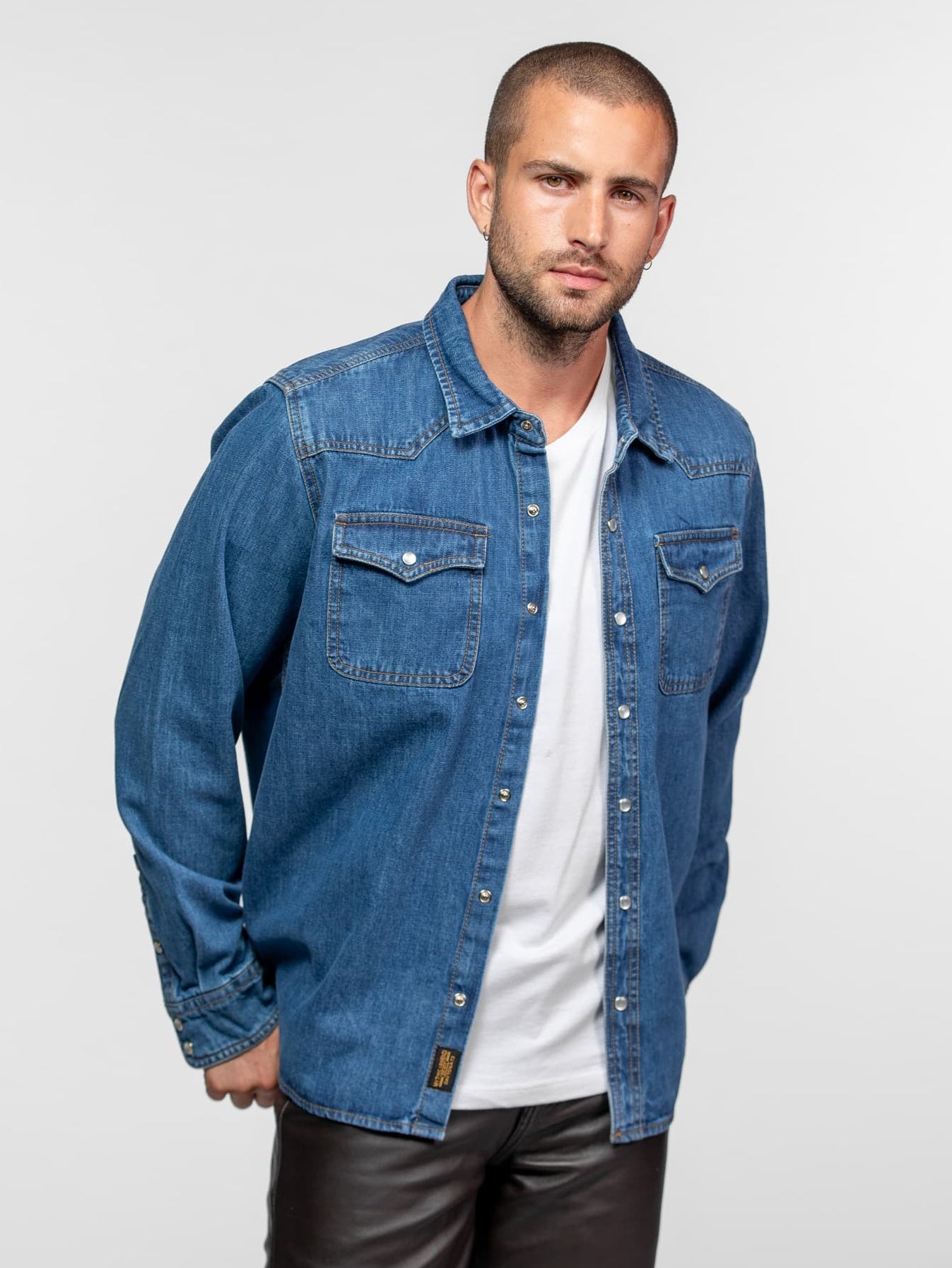 Chemise en jean bleu sur t-shirt blanc et pantalon.