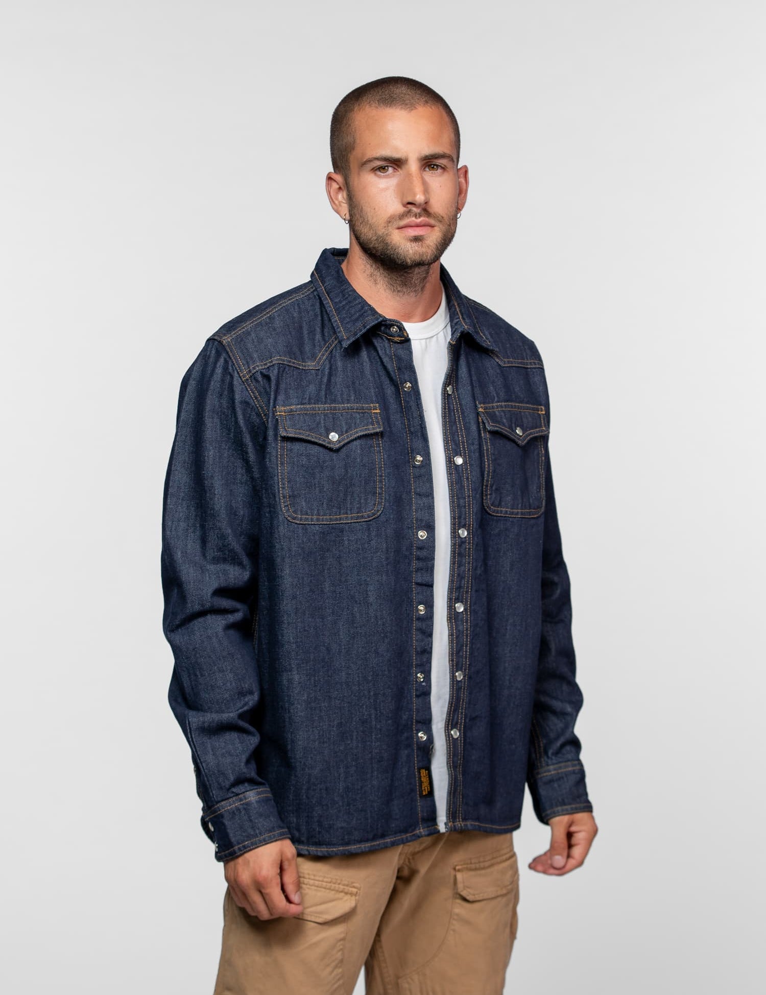 Chemise western en denim bleu brut à boutons pression.