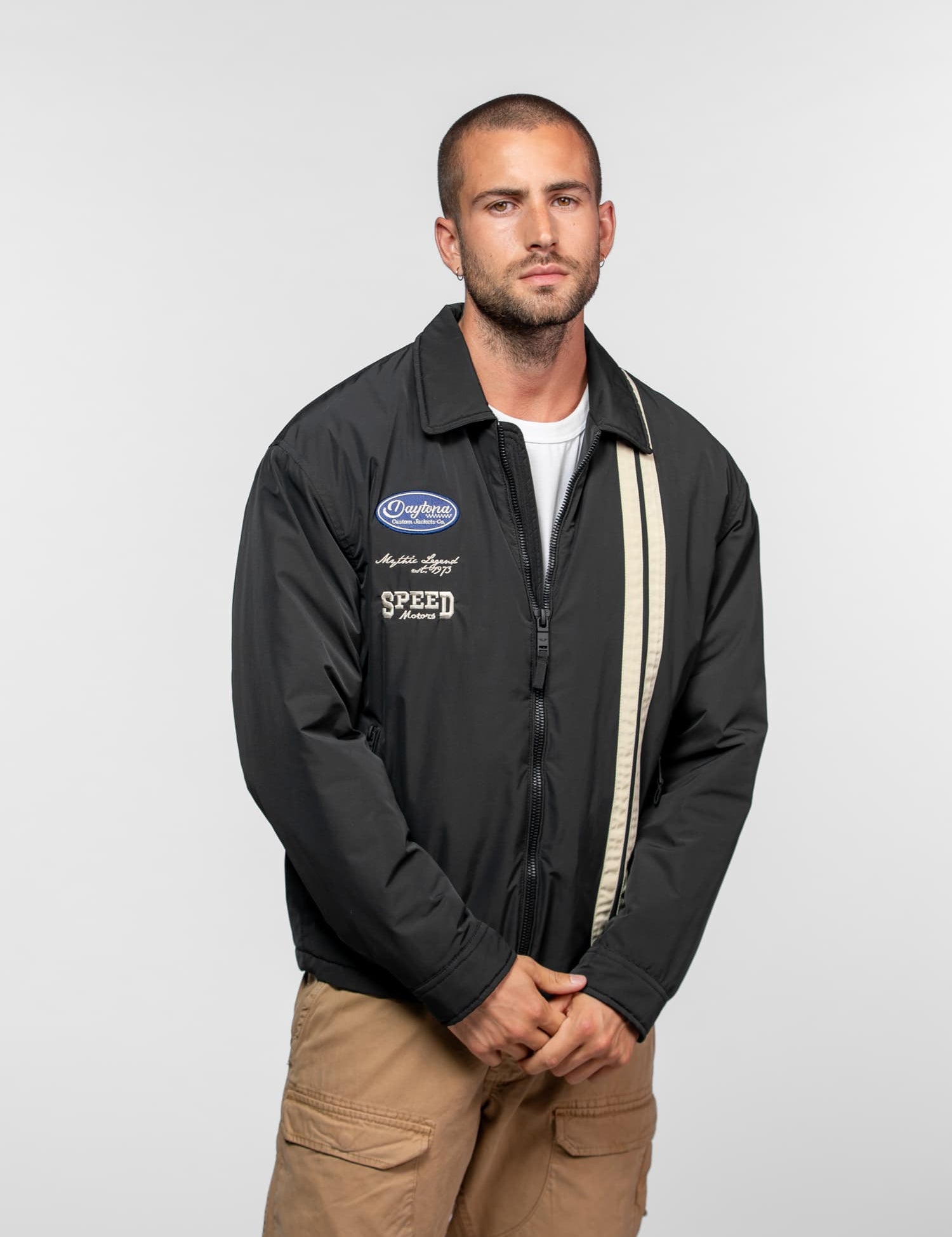 Homme portant un blouson noir avec bande beige.