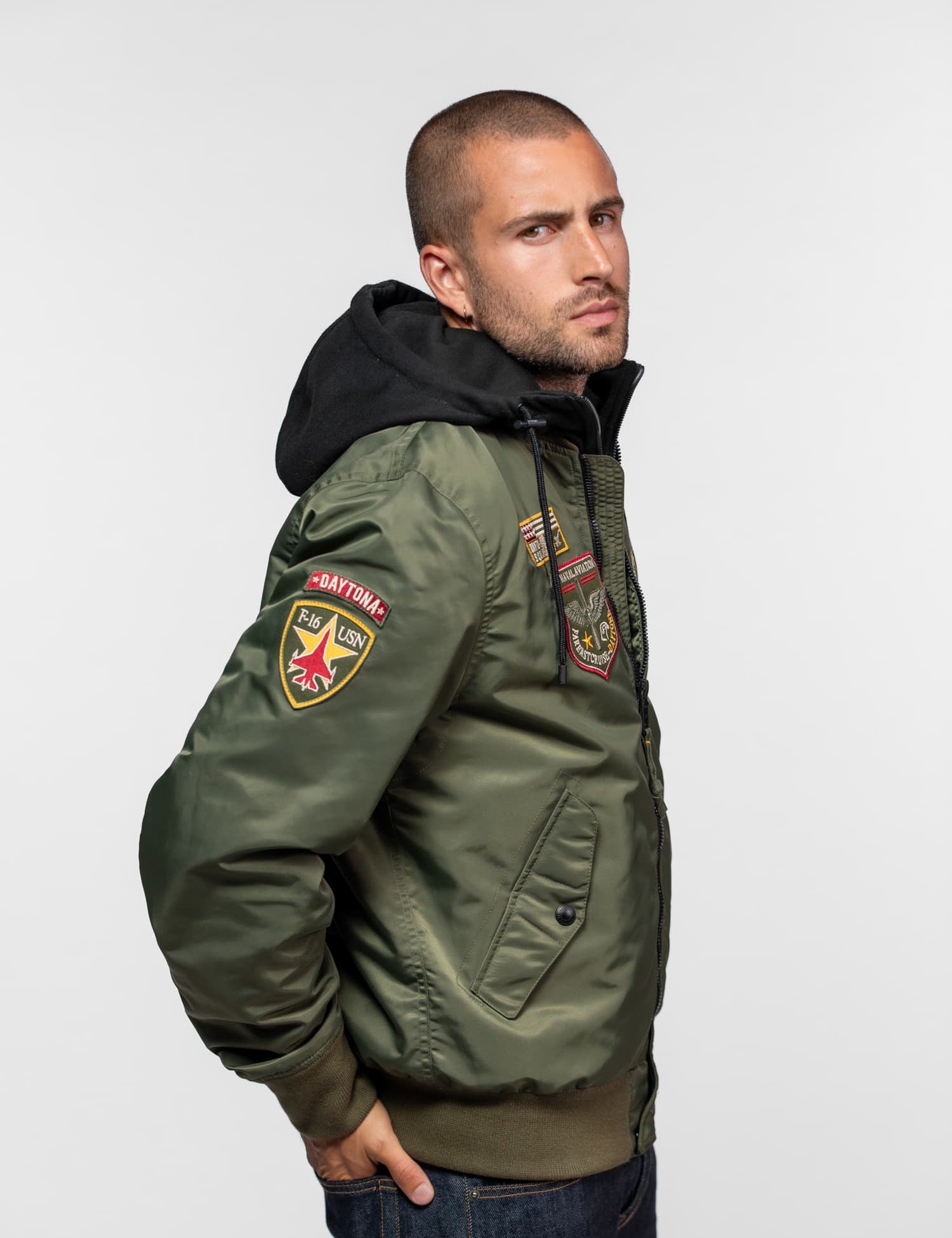 Homme portant un blouson vert avec des écussons.