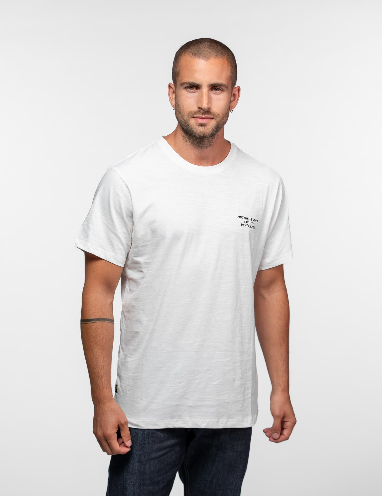 Homme en t-shirt blanc avec logo sur fond blanc.