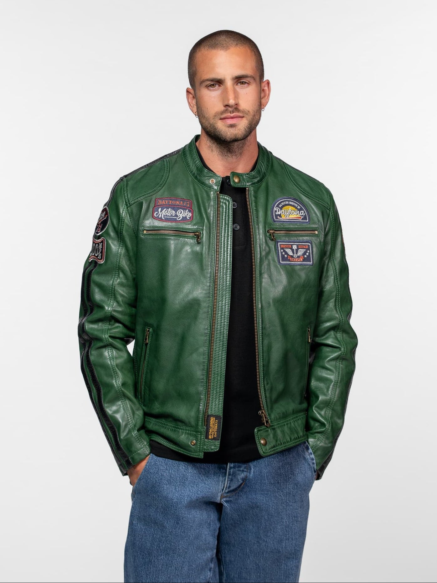 Homme portant un blouson de cuir vert avec écussons.