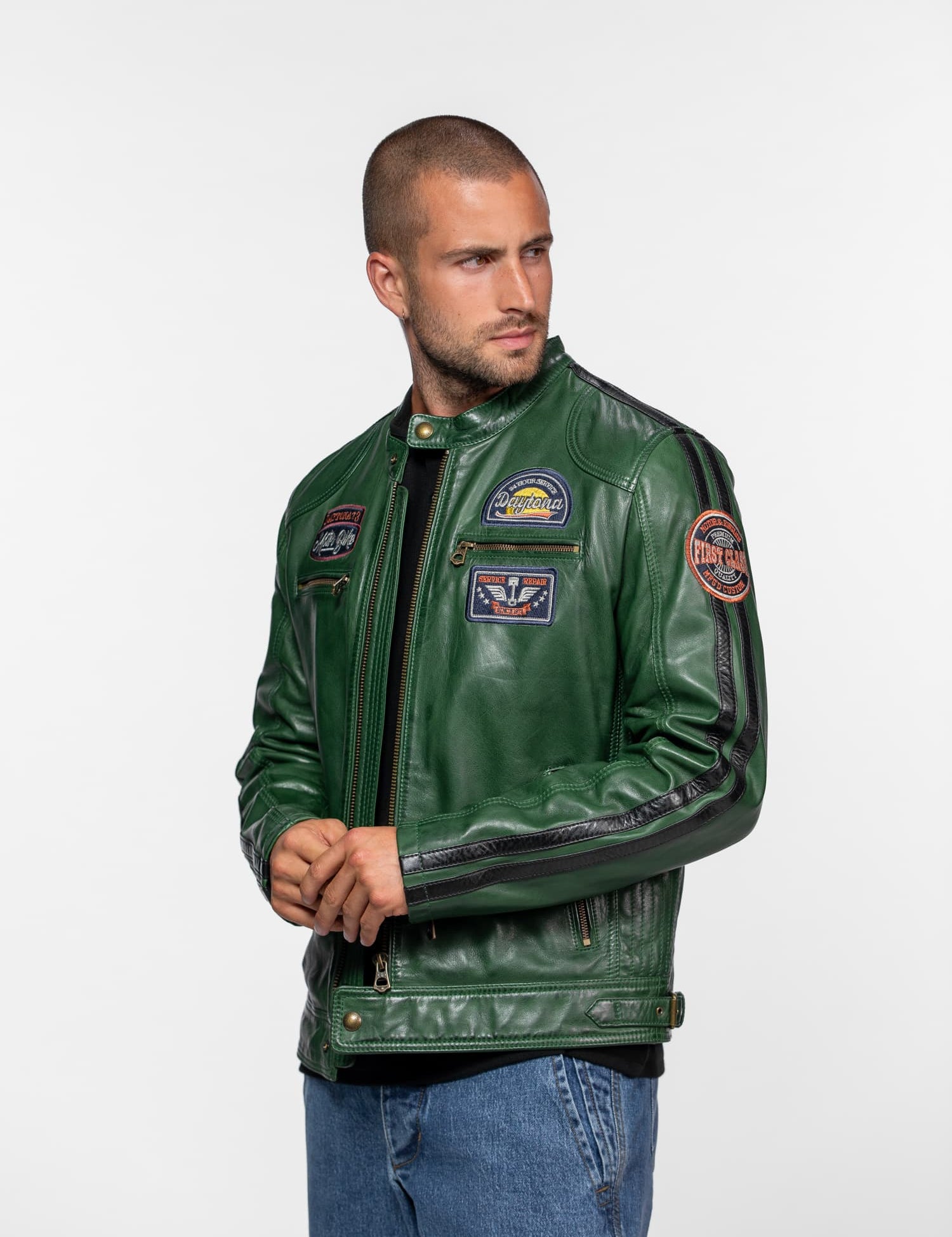 Homme portant un blouson en cuir vert avec écussons.