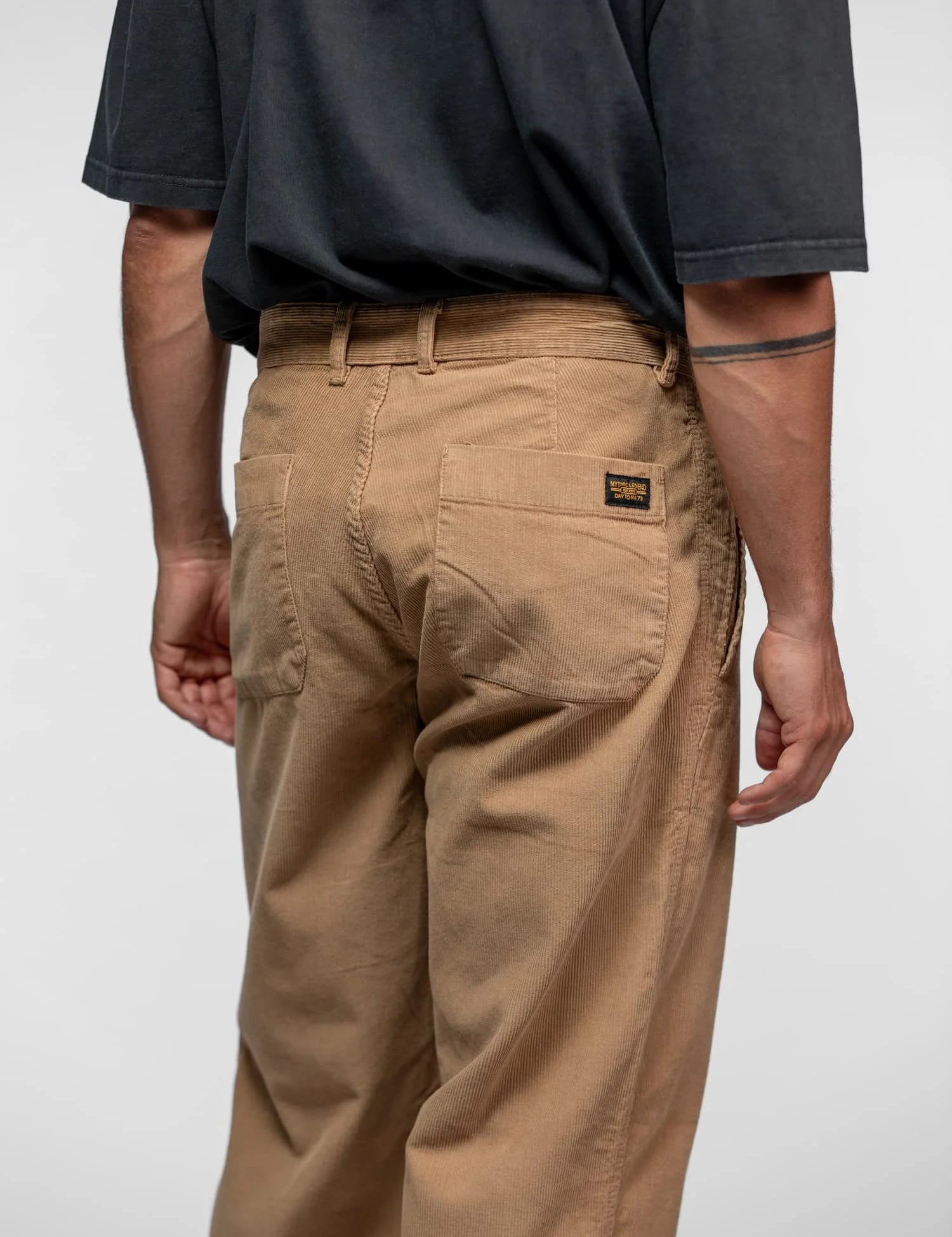 Homme avec chemise marron près d'une moto.