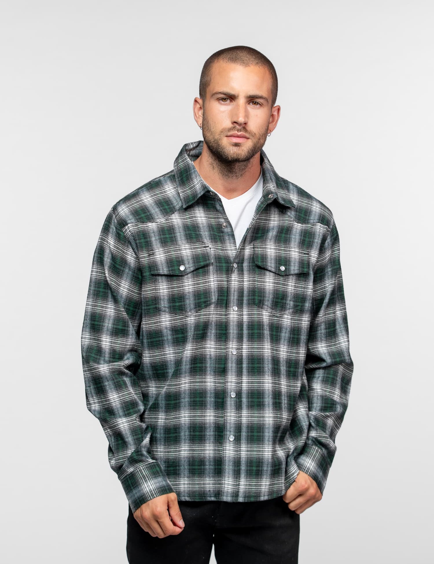 Homme portant une chemise à carreaux verte et blanche.