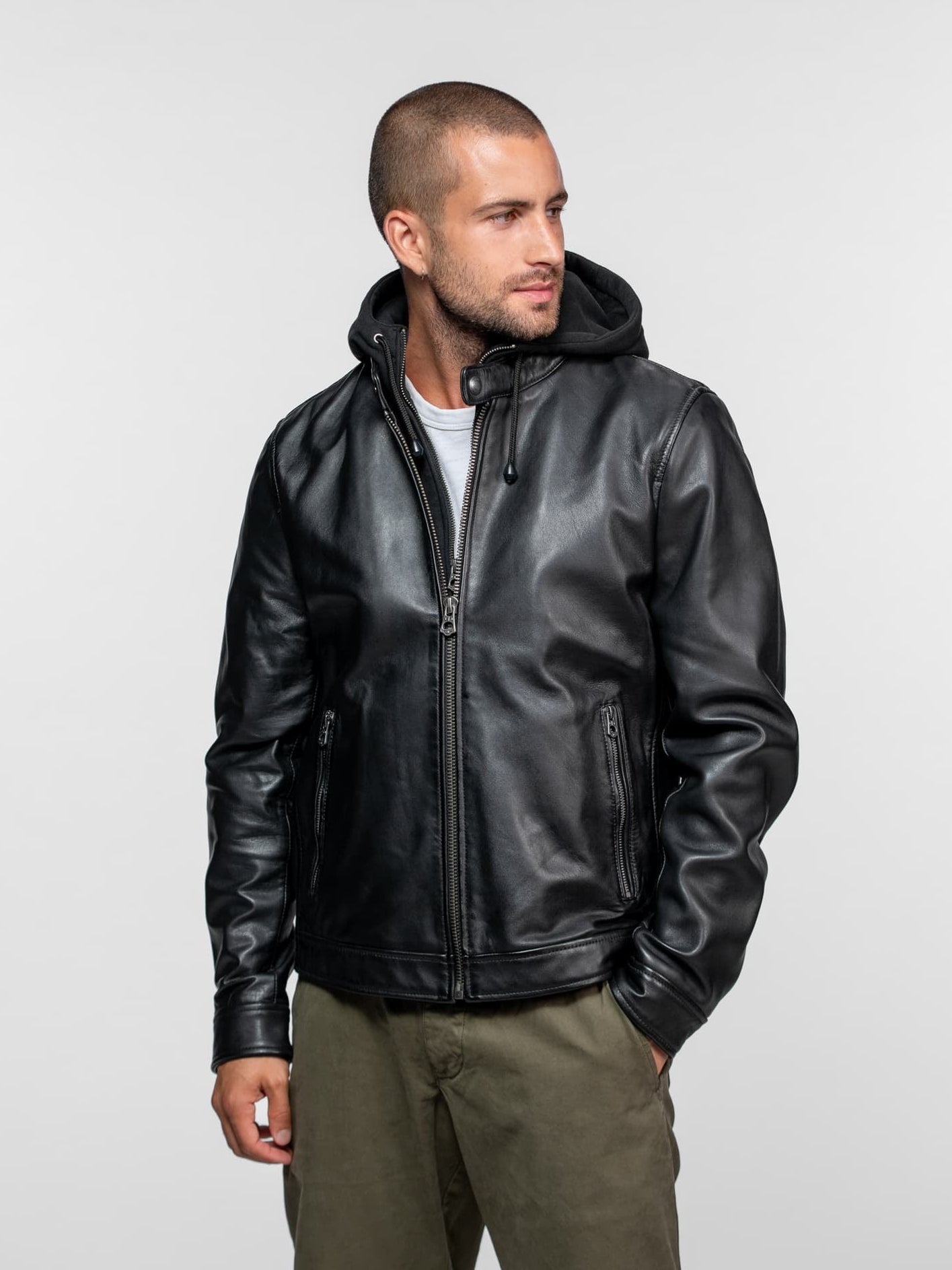 Homme portant un blouson en cuir noir à capuche.