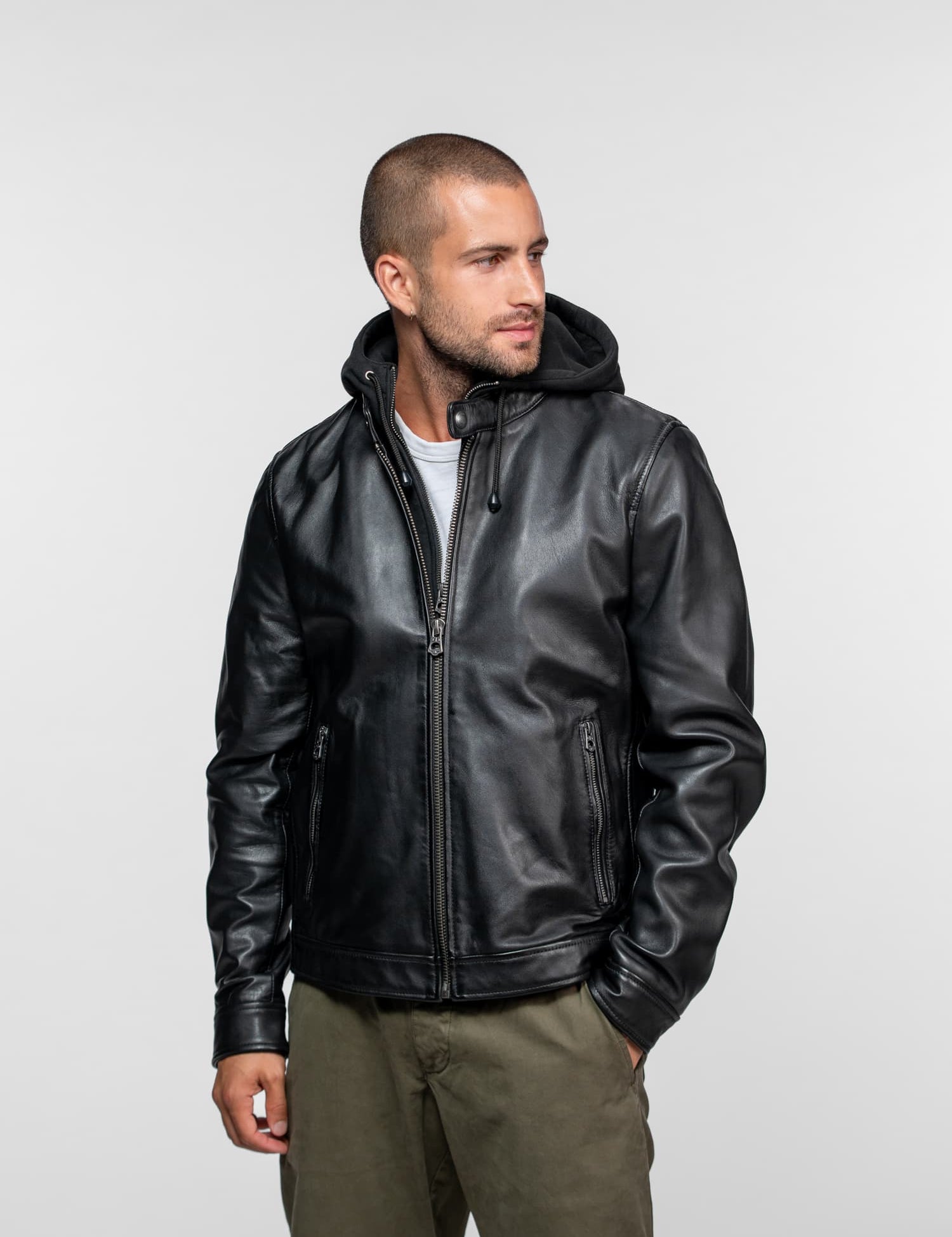 Homme portant un blouson en cuir noir à capuche.