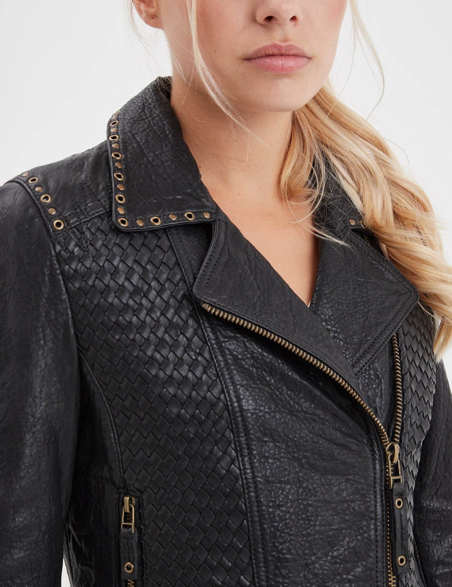 Veste noire en cuir tressé avec œillets et fermetures éclair.