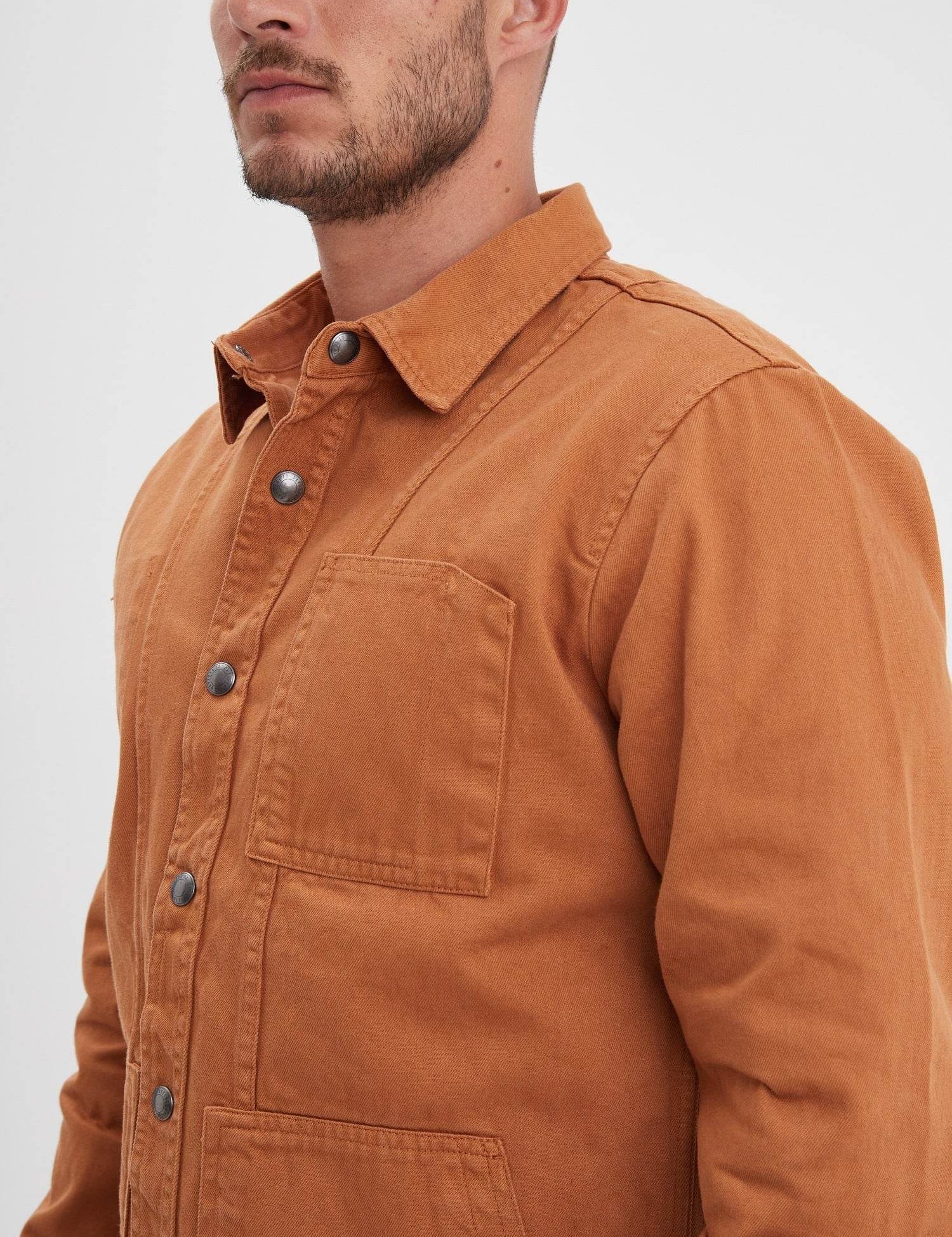 Veste de travail ocre avec boutons-pression et poche poitrine.