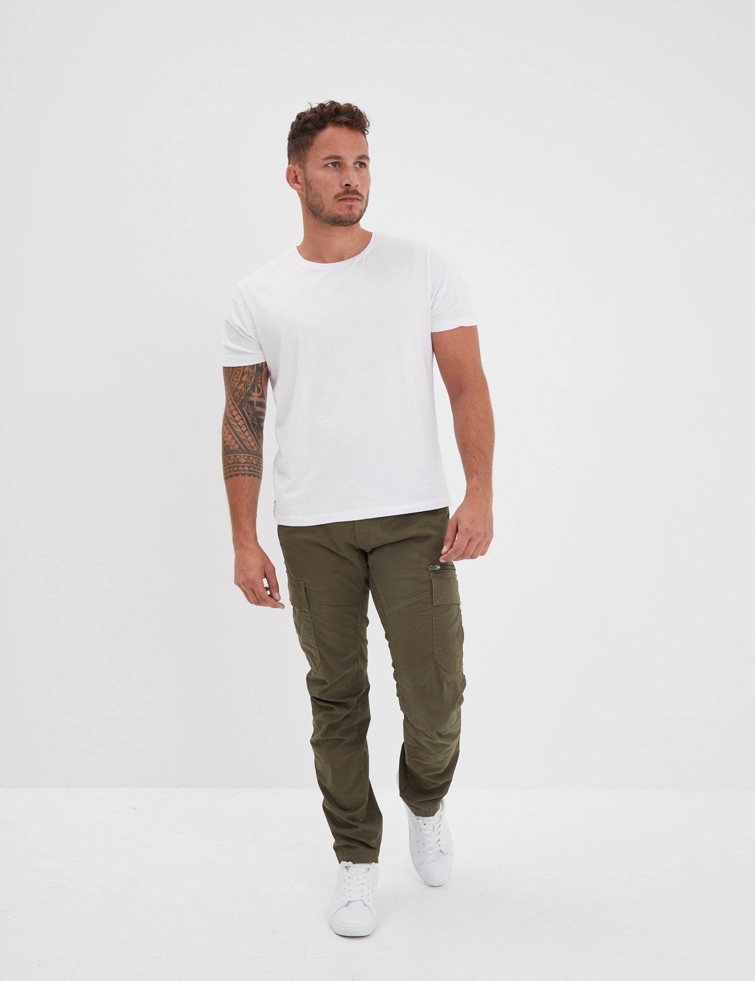 T-shirt blanc uni, pantalon cargo olive et baskets blanches.