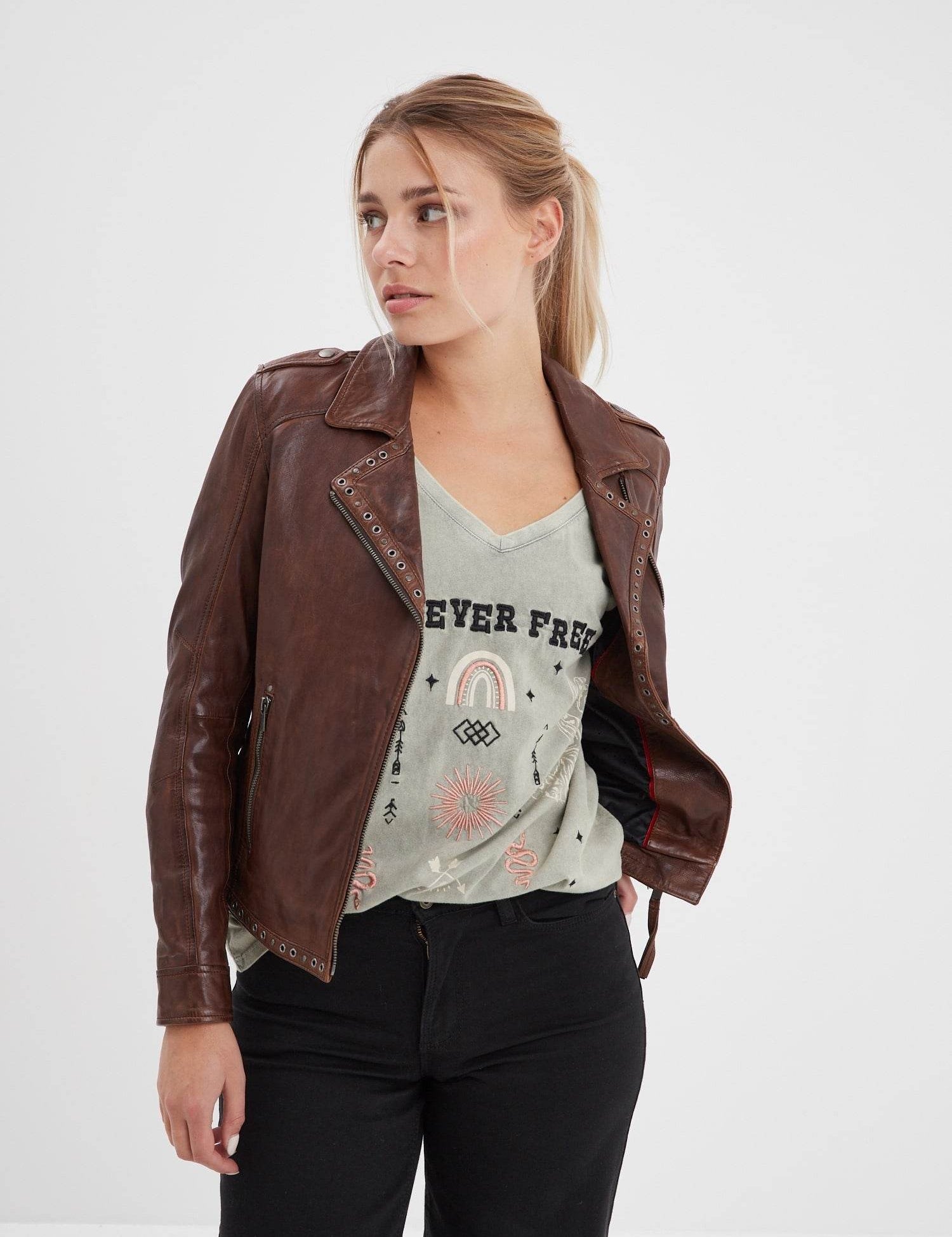 Femme portant un blouson en cuir marron clouté.