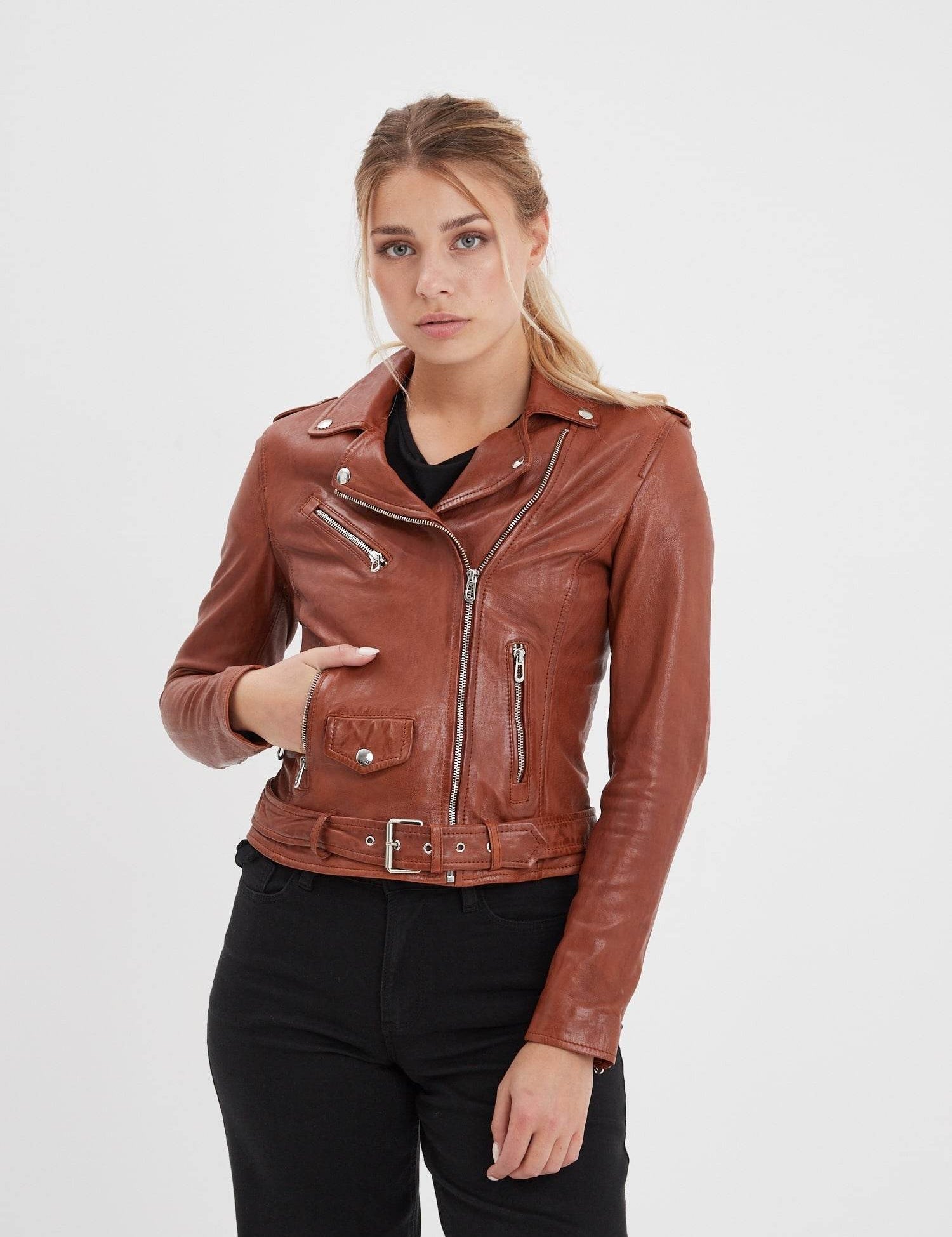 Femme portant un blouson en cuir marron et jean noir.