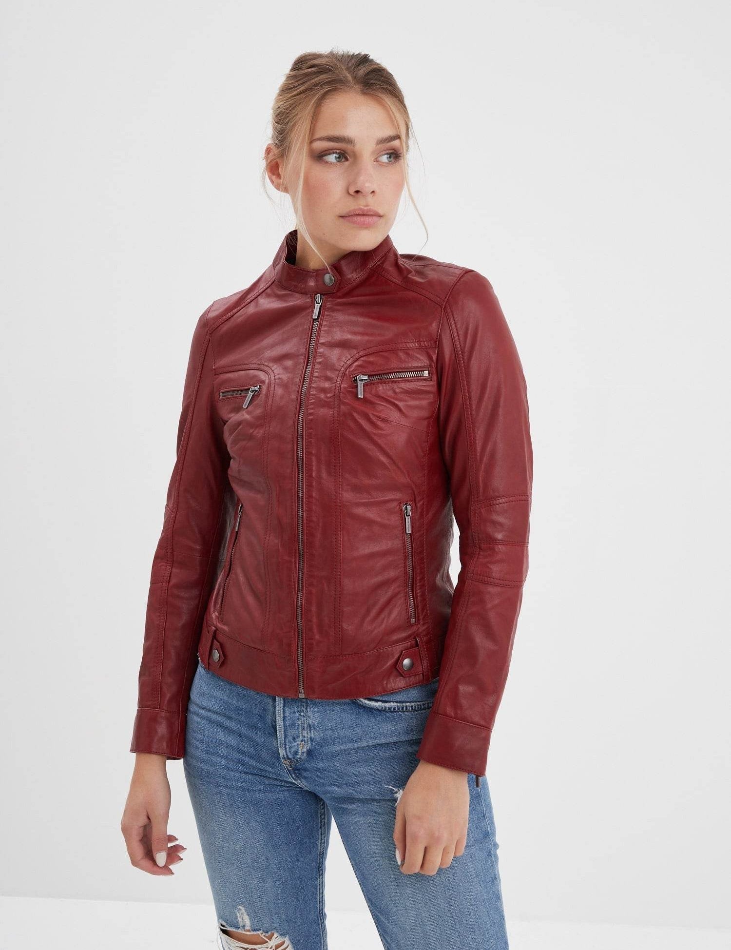 Femme portant un blouson en cuir rouge et jean.