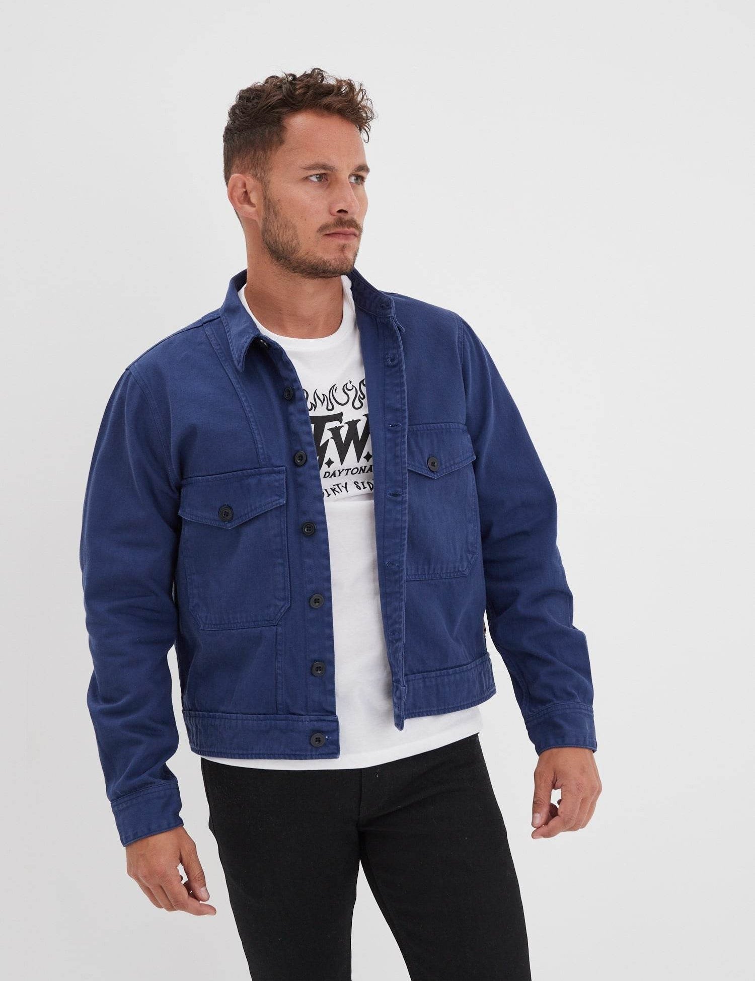 Homme en veste bleue, t-shirt blanc et pantalon noir.