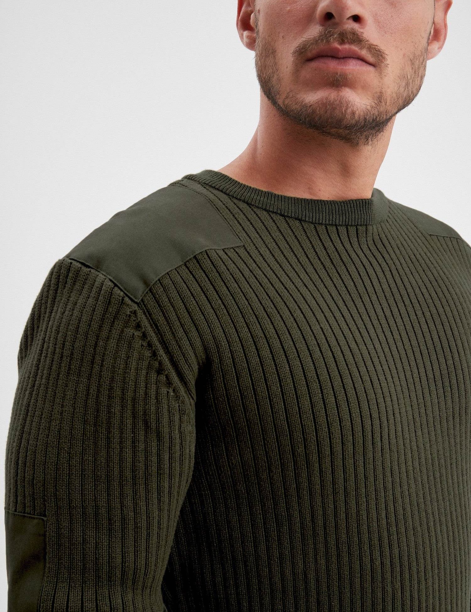 Détail d'un pull en maille côtelée vert olive.