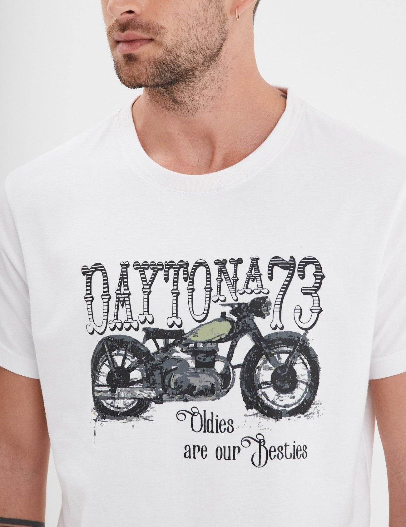 Man in a white shirt with "Daytona 73" and a vintage motorcycle design, text reads "Oldies are our Besties."