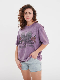 Femme portant un t-shirt violet avec imprimé aigle.