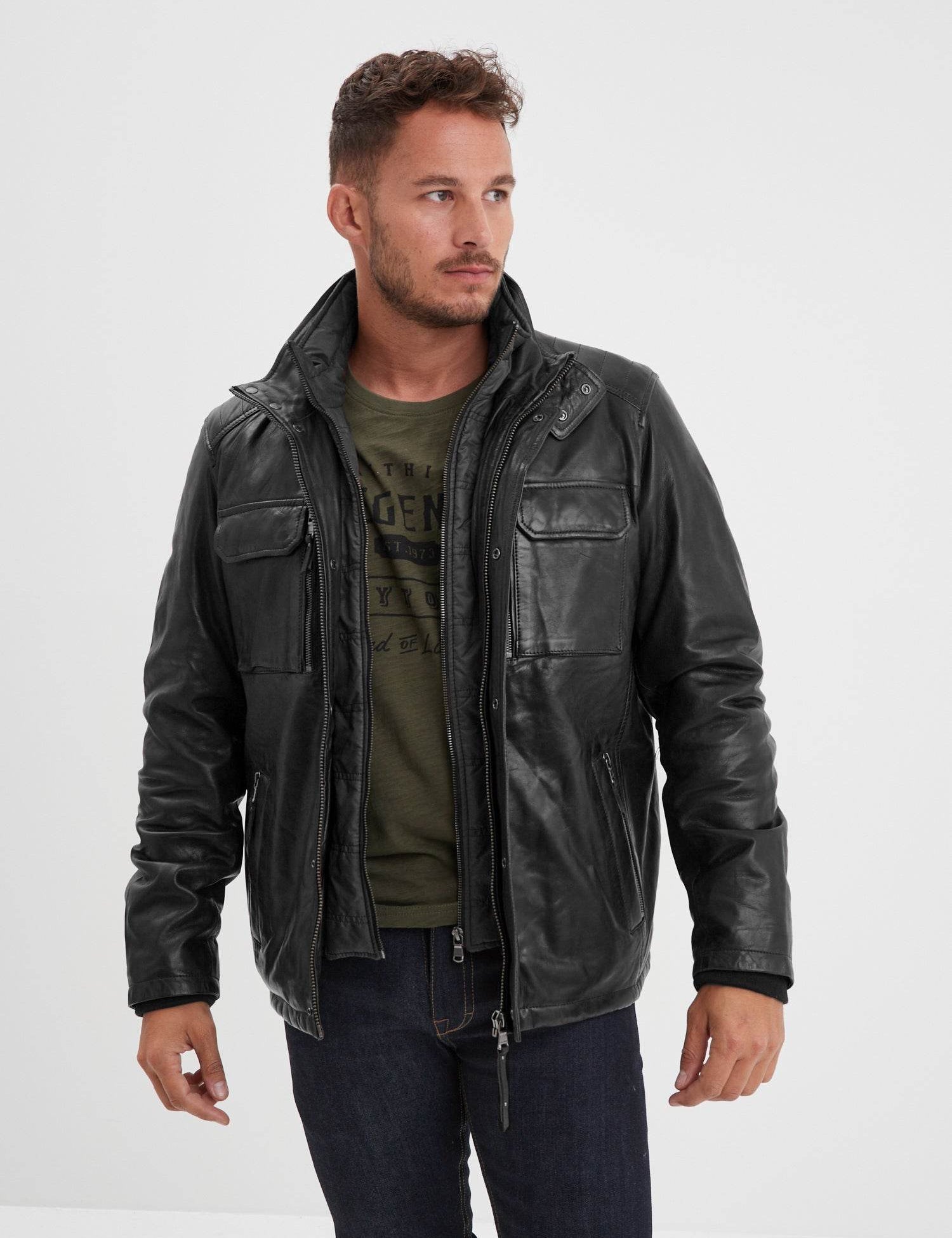Homme portant un blouson en cuir noir sur fond blanc.