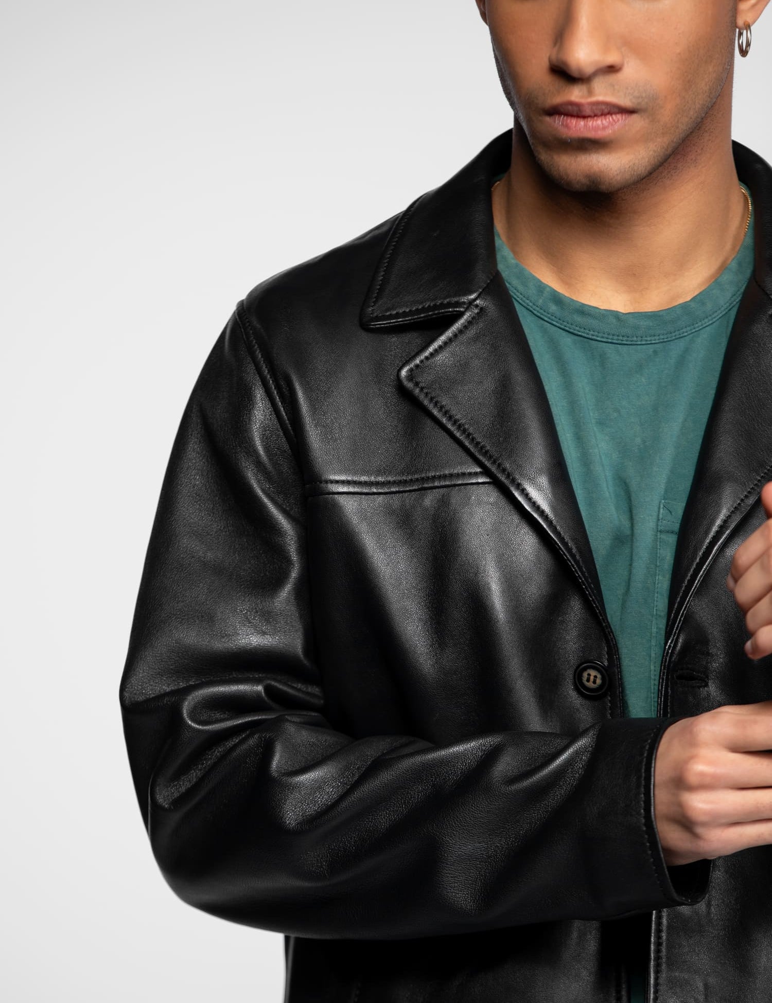 Veste en cuir noir avec revers et bouton apparent.