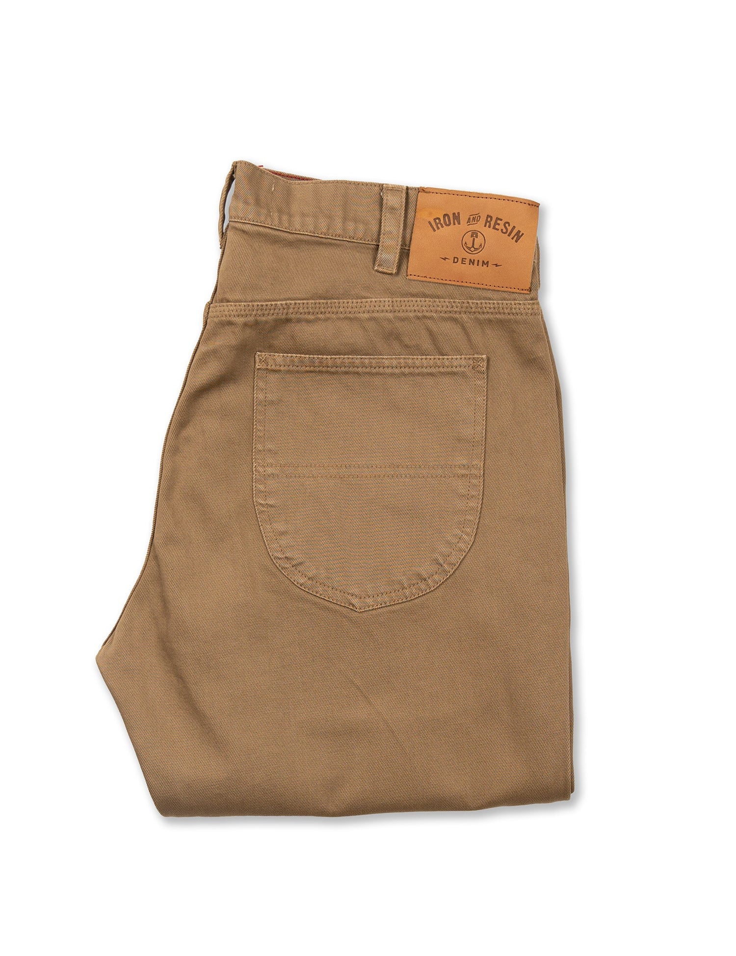 Pantalon beige plié avec étiquette en cuir à la taille.