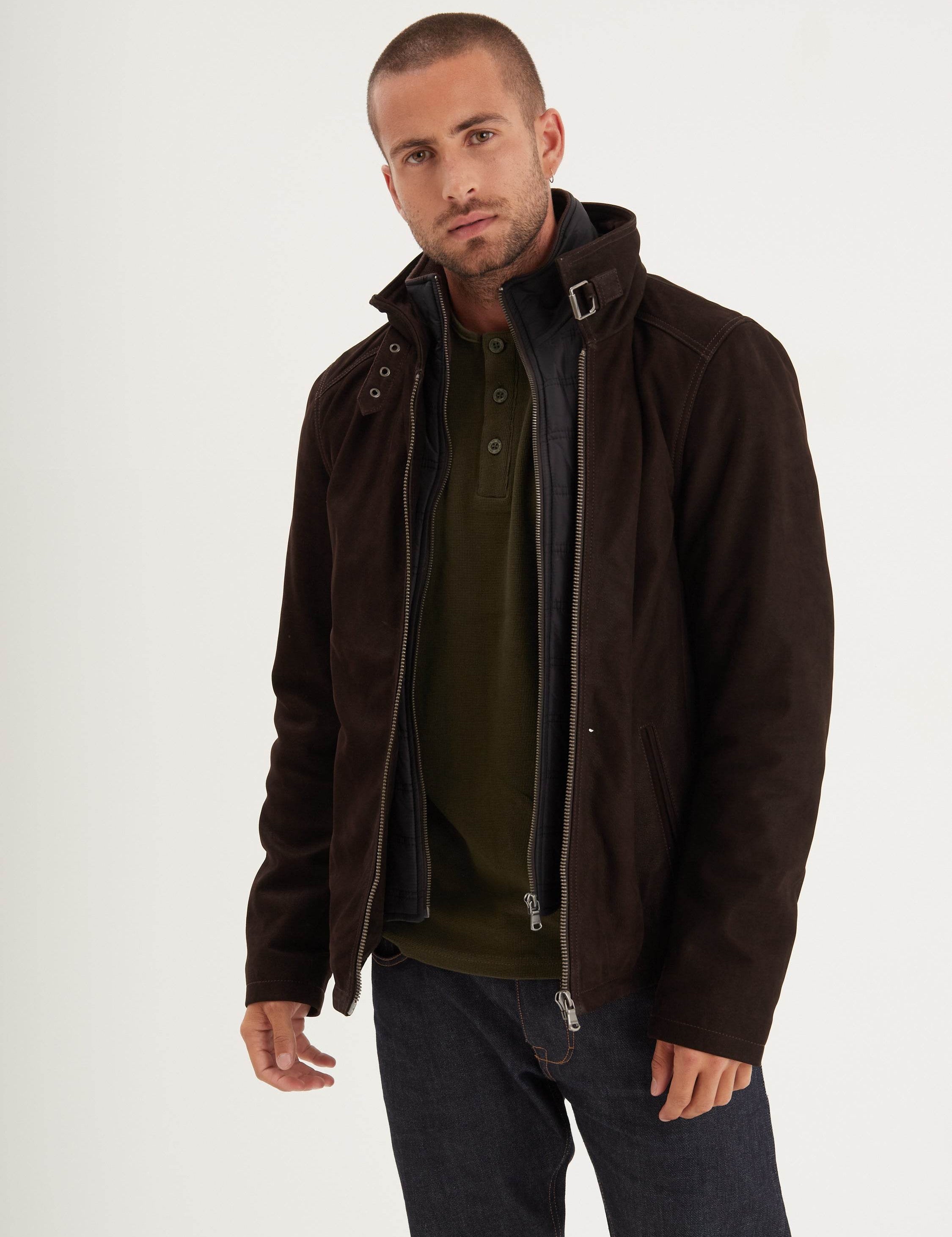 Blouson marron foncé à fermeture éclair sur un henley olive.