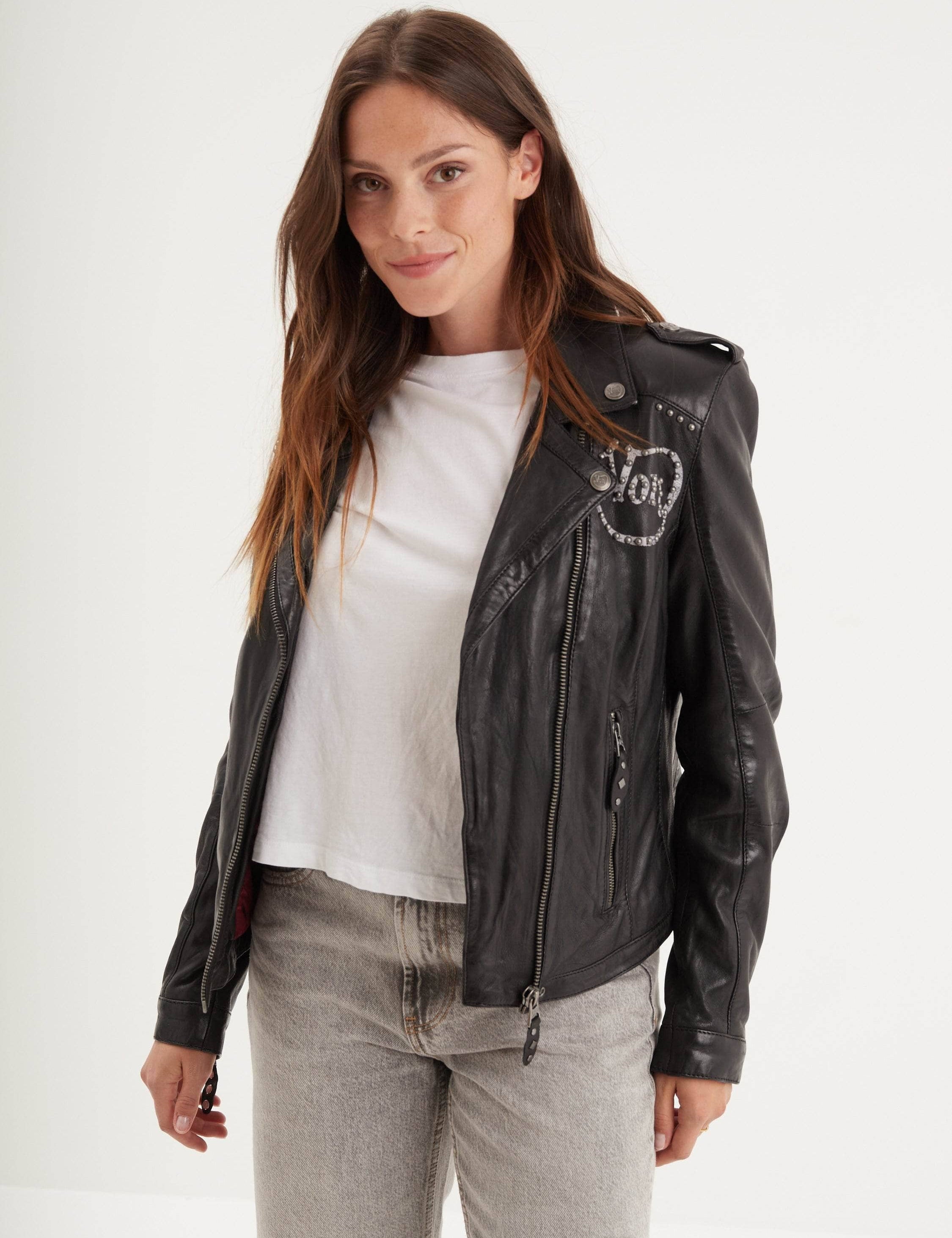 Femme portant une veste en cuir noir et un t-shirt blanc.