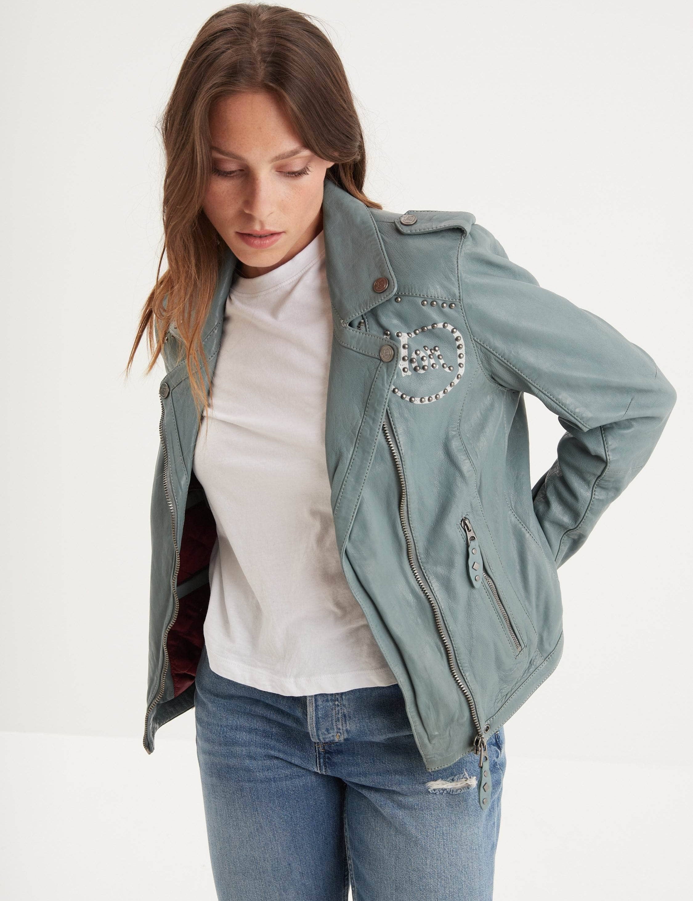 Femme portant un blouson en cuir bleu clair clouté.