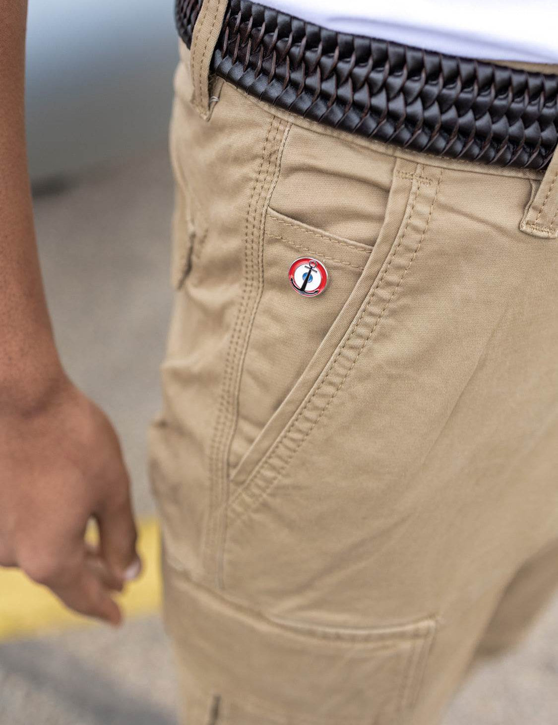 Pantalon cargo beige avec un petit badge rond tricolore.