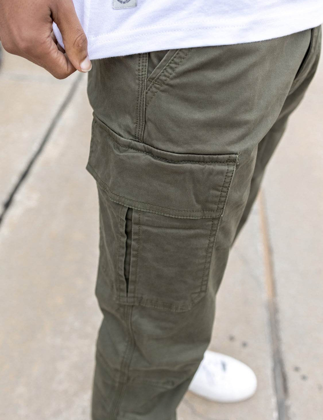 Gros plan sur un pantalon cargo vert olive.